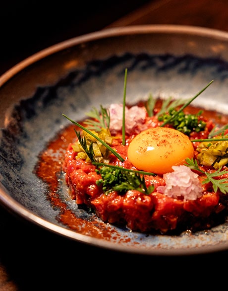 Steak Tartare in plate with ingredients and garnish on top at Stella Steakhouse